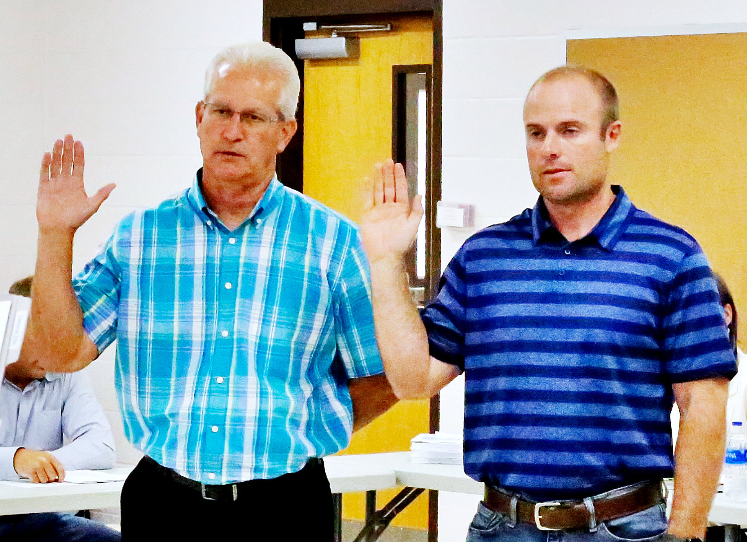Newly-elected Alba-Golden School Board trustees Dwayne Ellis, left, and Matt Haisten are sworn in by Director of Finance Brenda Kelley at Monday’s board meeting. See related photo Page Two.